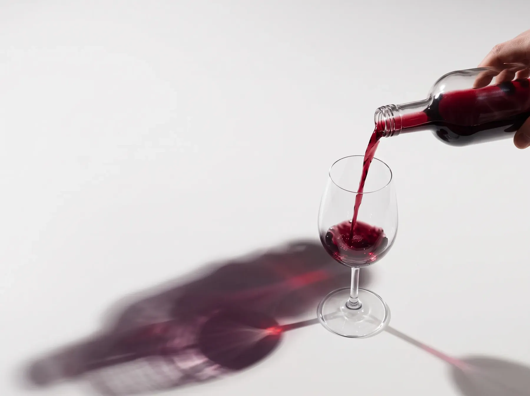 A mini bottle pouring red wine into a glass